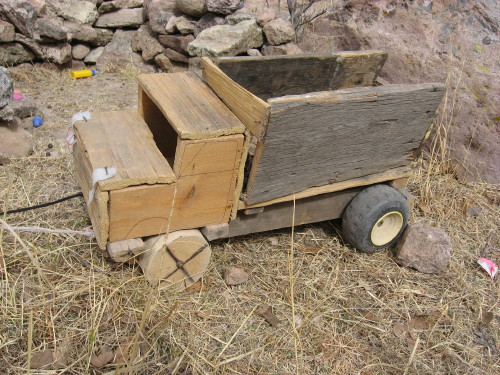 A kid's joy is his toy, and indicative of daily life: in this case a logging truck.